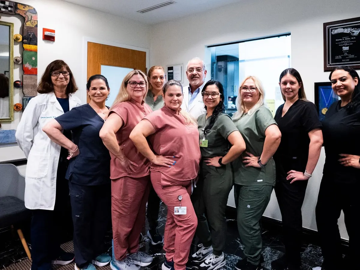 Dr. Martin N. Zaiac with the Greater Miami Skin & Laser Center staff, posing together in the office hallway