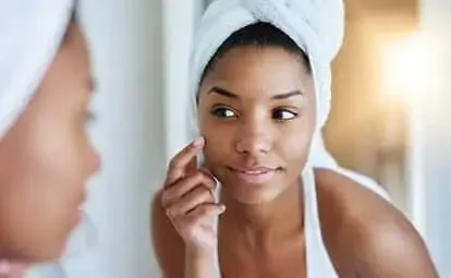 woman applying acne cream to her face