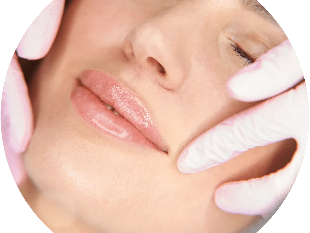 Close-up of a woman's lips and chin as gloved fingers touch her face