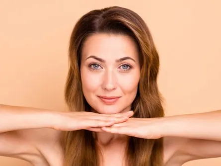 Woman has refreshed face and hands after cosmetic treatments.