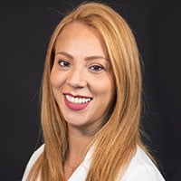 Katty Serrano, Medical Assistant Supervisor, smiling, with long auburn hair
