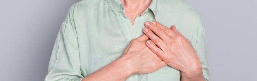 A model in a light green shirt pressing both hands to the chest