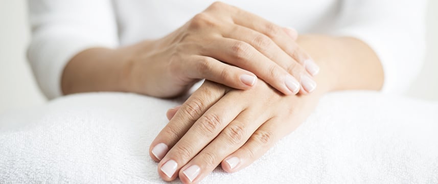 close up of person's hands as there are sitting with one hand resting on the other
