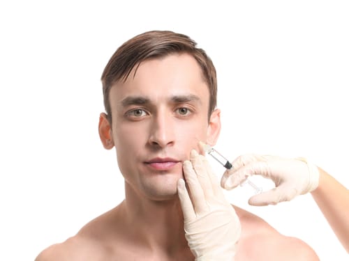 Handsome man receiving filler injection on white background